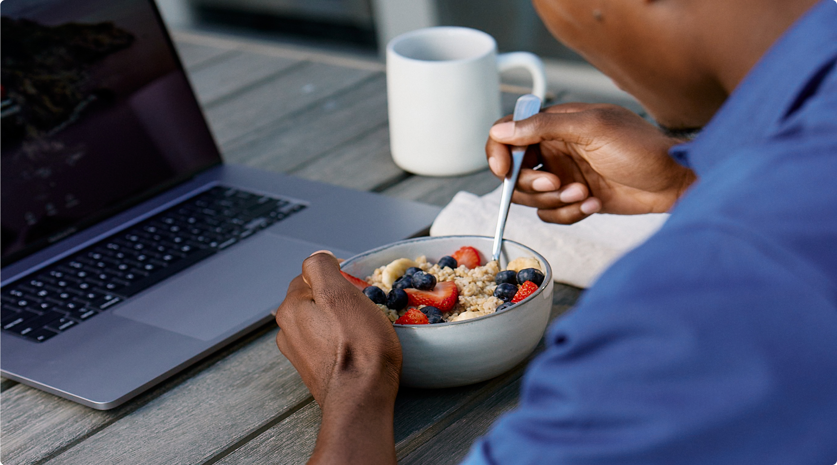 Man sitting at his computer while eating oatmeal